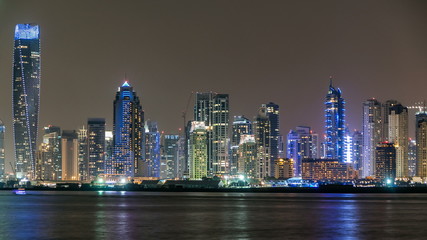 Dubai Marina skyline night timelapse as seen from Palm Jumeirah in Dubai, UAE.