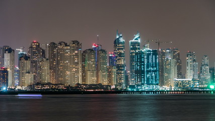 Dubai Marina skyline night timelapse as seen from Palm Jumeirah in Dubai, UAE.