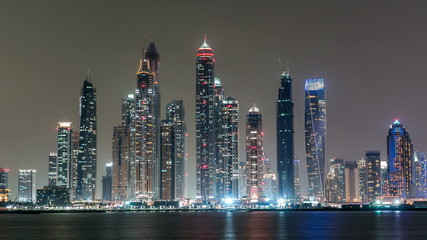 Dubai Marina skyline night timelapse as seen from Palm Jumeirah in Dubai, UAE.