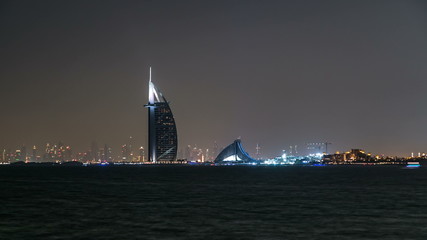 Skyline of Dubai at night timelapse with Burj al Arab in foreground in Dubai, United Arab Emirates
