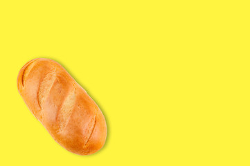 Whole baked bread on yellow background with copy space for your text