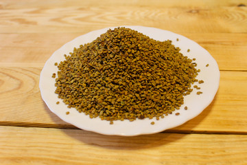 Egyptian yellow tea or Helba in a plate on a wooden table