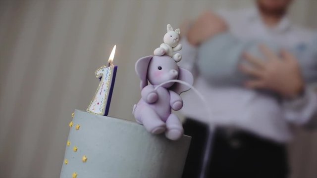 Father throws up the baby in his arms, the first birthday party. Celebrating first birthday with gourmet cake, copy paste place for text