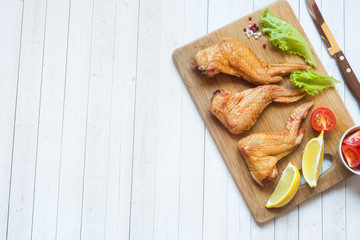 Smoked chicken wings with fresh lettuce tomato and lemon. Copy space