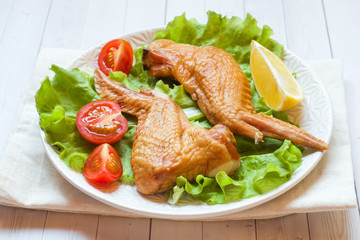Smoked chicken wings with fresh lettuce tomato and lemon