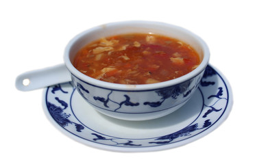 Chinesische sauer-scharf Suppe (Peking-Suppe) in traditioneller Keramik-Schüssel mit blauer...