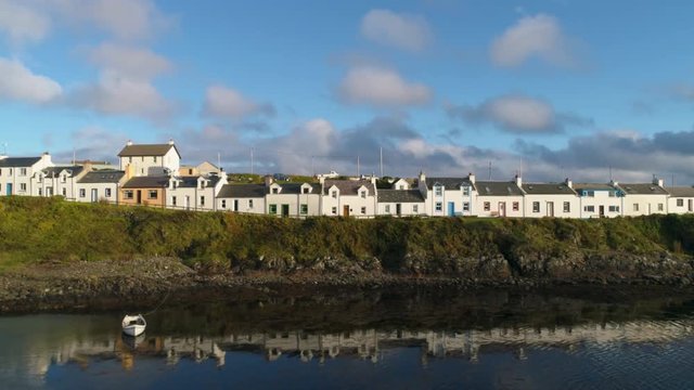 Stunning Aerial Drone Shot in Scottish Highlands, facing cottages in Portnahaven bay on the Isle of Islay