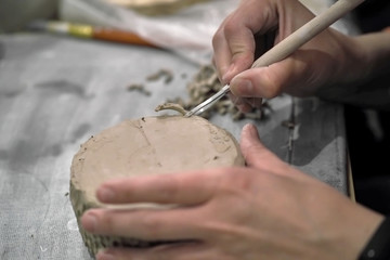 TThe manufacture of pottery, hands with the tool and the product close-up