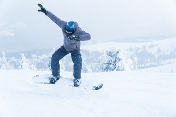 Fototapeta na wymiar male snowboarding snowboard jump. go in the mountains on Snow Mountain winter snowboarding.