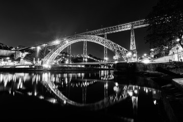 Luis I Bridge in the night in Porto, Portugal, Europe. Night reflection in de water of the river. Night black and white image.