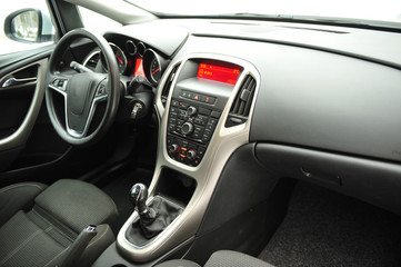 Fototapeta na wymiar Modern luxury prestige car interior, dashboard, steering wheel. Black perforated leather interior.