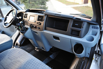 Modern luxury prestige car interior, dashboard, steering wheel. Black perforated leather interior.