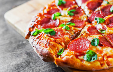 Pepperoni Pizza with Mozzarella cheese, salami, Tomatoes, pepper, Spices and Fresh Basil. Italian...