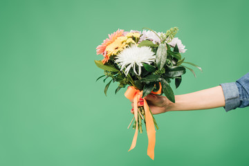 cropped view of woman holding flower bouquet isolated on green © LIGHTFIELD STUDIOS