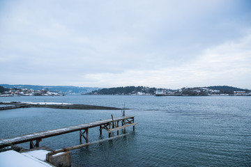Fototapeta na wymiar A pier for boats traveling between the Islands around Oslo Norway during the winter overlooking the sea and the Fjord