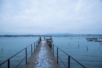 Fototapeta premium A pier for boats traveling between the Islands around Oslo Norway during the winter overlooking the sea and the Fjord covered by snow