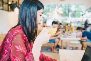 Young fashion women sittng on vintage sofa hold hot latte coffee