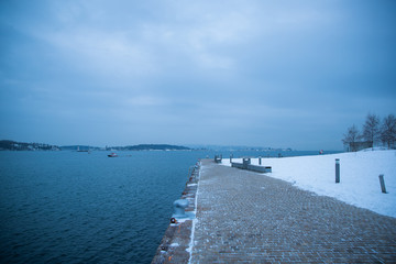 Fototapeta na wymiar Oslo Norway coast during winter with a large number of docked boats in the center of the city covered with snow