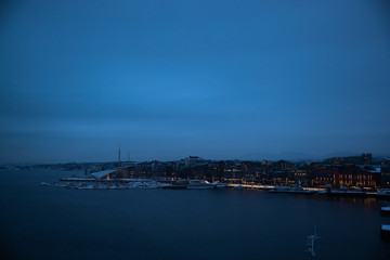 Oslo Norway coast during winter with a large number of docked boats in the center of the city covered with snow