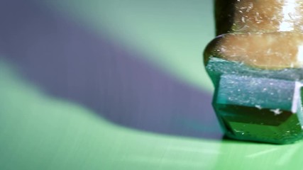 An gemstone cutter polishes a emerald on a faceting machine with chromium oxide in a cutting and polishing workshop.