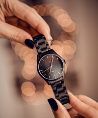 Stylish black watch in hands