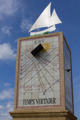 Reloj de sol con veleta de barco de vela tradicional visto desde abajo con fondo de cielo azul con...