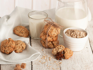 Oatmeal cookies with milk on tray on rustic wooden table