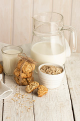 Oatmeal cookies with milk on tray on rustic wooden table