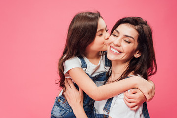 daughter kissing happy mother isolated on pink - Powered by Adobe