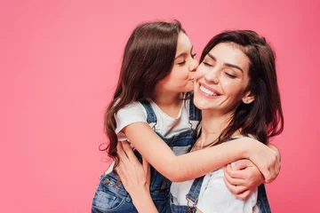 Fotobehang daughter kissing happy mother isolated on pink © LIGHTFIELD STUDIOS