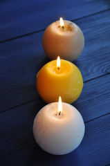 Burning spherical candles on the wooden background