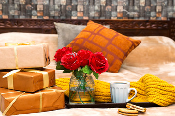  chocolate cookies, cup of coffee, roses vase in tray and boxes gift for holiday during on bed  the morning