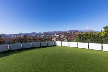 Terrace with synthetic lawn overlooking the city of Lugano in Switzerland