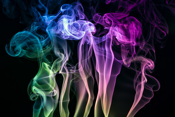 Colorful smoke of incence stick isolated at black background