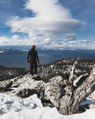 Snowboarder at Summit Gazing at Lake Tahoe and Snow Capped Mountains