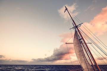 Sail at sunset, endless travel concept, color toned picture.