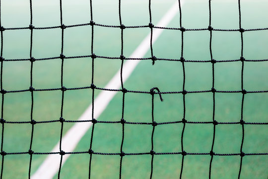 A Hole In A Tennis Net On Court