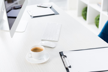 high angle view of cup of coffee and clipboard on table in business office