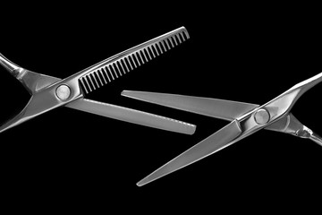 Barber scissors. Barber tool. Professional barber scissors on a black background.
