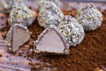 Chocolates and cocoa on wooden background.