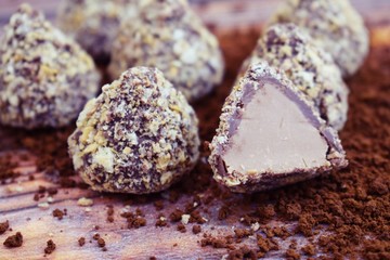 Chocolates and cocoa on wooden background.