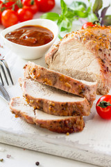 Baked Meat. Roast pork Meat with honey-mustard glaze served on a chopping board with ketchup on kitchen table.