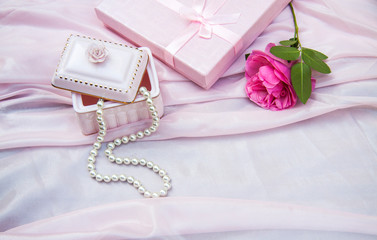 pink background with a box and pearl beads