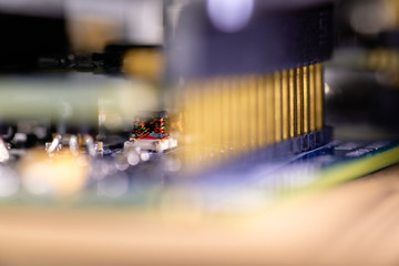 Close up (Macro) of Printed Circuit Board PCB embedded components (inductors, resistors, capacitors, diodes, microchips, transistor) with short depth of view. 