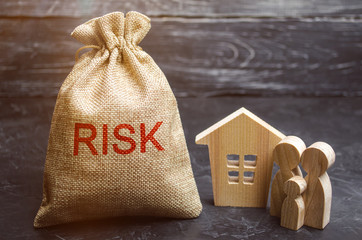 Naklejka premium A bag with money and the word risk and a wooden house. Buying property on credit. The concept of financial risk. Loss of housing for failure to pay. Property insurance. Mortgage and tax. Real estate