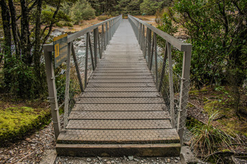 Obraz premium footbridge at walking track to Devil's Punchbowl Waterfall at Arthur's Pass National Park, South Island, New Zealand