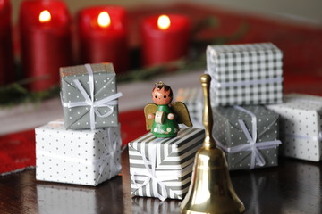 Hintergrund mit Weihnachtsengel Figur, Geschenke, Handglocke und Kerzen an Weihnachten.