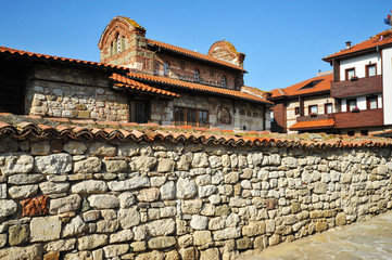 Stone old house with a tiled roof and a large stone fence in Bulgaria