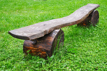 wooden old bench on a background of green grass