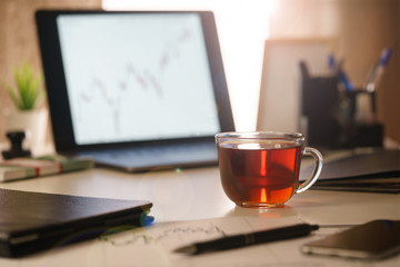An image of a morning, office desk of a financial analyst close-up.